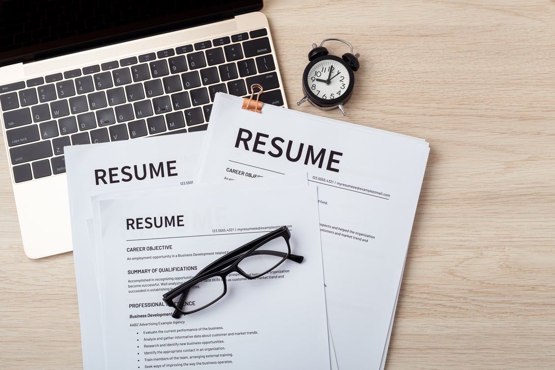 Resumes on laptop with glasses resume review, job interview